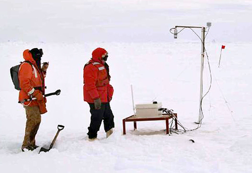 Scientists with instrument on ice floe.